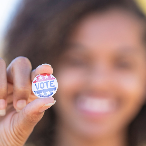 Young person holding a Vote button