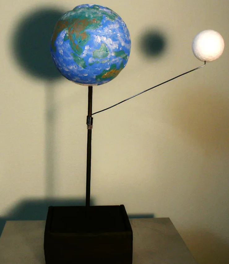 A model of Earth and its moon, showing the Moon's shadow.