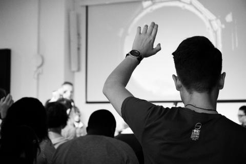 man raising hand in classroom