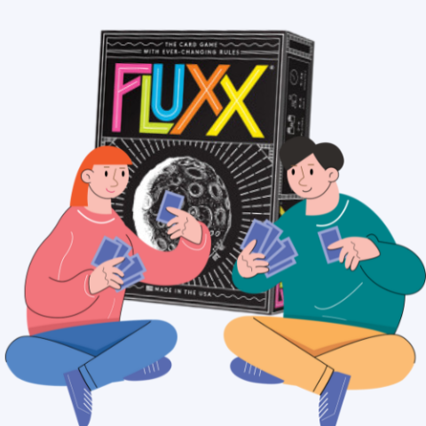 Two people playing cards in front of an enormous Fluxx card game box