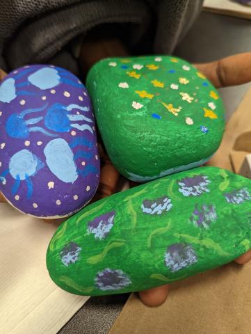 3 painted rocks in green and purple