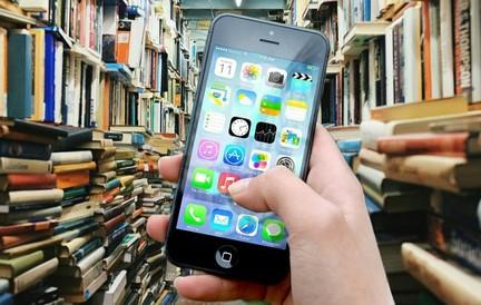 A hand holding a phone in a library