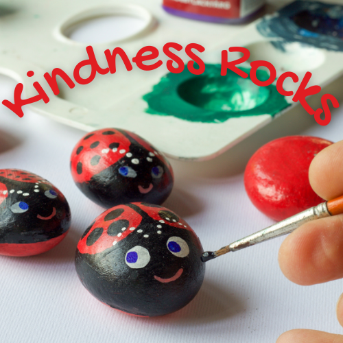 A hand painting ladybug-themed "Kindness Rocks"