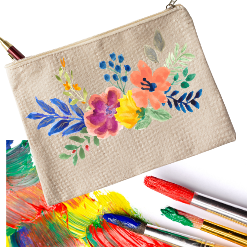 A canvas zipper pouch holding a pen, with a bouquet of flowers painted on the pouch. In the background, some acrylic paint smears and several paintbrushes with paint on them.