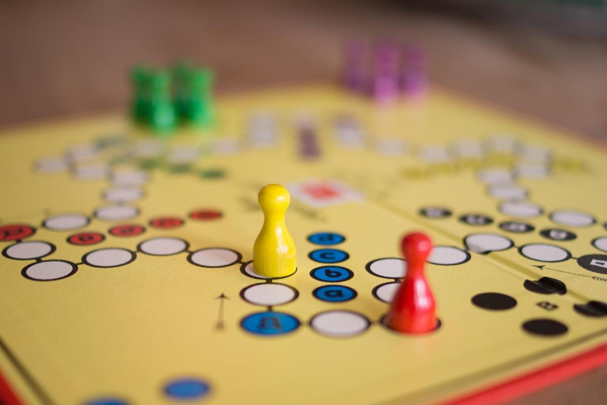 A "sorry" like board game on a yellow board, complete with gaming pieces.